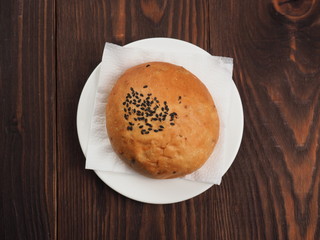 Sesame bun on a plate and wooden table