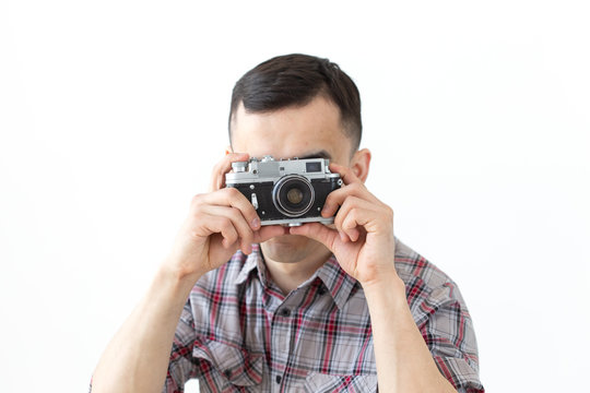 People hobby and leisure concept - young asian man using his vintage camera on white background
