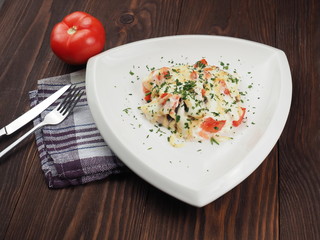 Chicken meat with cheese sauce in a triangular plate on the table