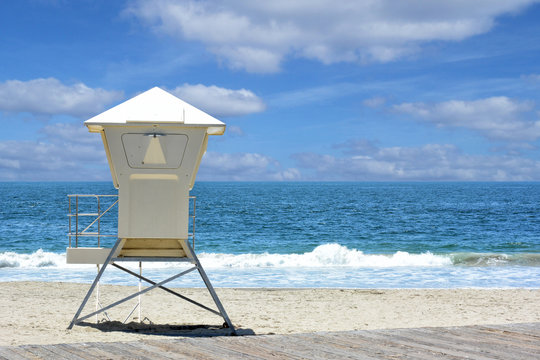 Lifeguard stand on a beach with the ocean and waves and cloudy sky