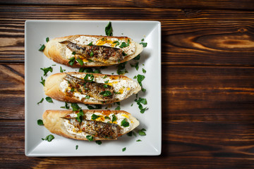 toast with sardines on a wood background closeup. top view