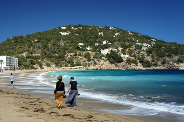 People strolling along the beach in windy weather.Ibiza Island.Spain.