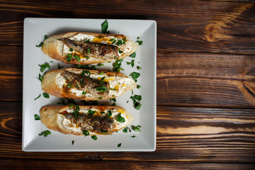 toast with sardines on a wood background closeup. top view