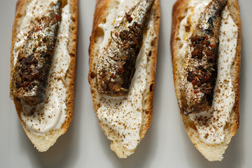 toast with sardines on a wood background closeup. top view
