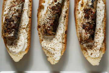 toast with sardines on a wood background closeup. top view