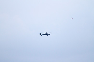 Military helicopters on blue sky with clouds and birds.