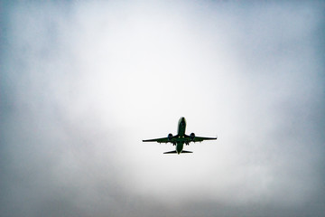 Aircraft on a background of cloudy sky. Landing a liner close-up. Spring. Day.