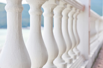 Beautiful white fence of columns on the waterfront by the sea