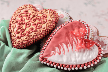 A pair of beautiful home-made gingerbreads for a wedding celebration or Valentine's day next to flowers on a table, closeup.