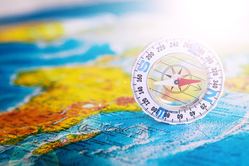 Compass on map. The magnetic compass is located on a geographic map. Satellites adventure. Travel concept.