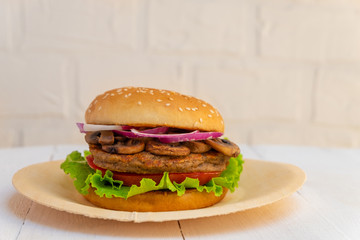 Black Bean and Mushroom Burger on white wooden background with copy space.