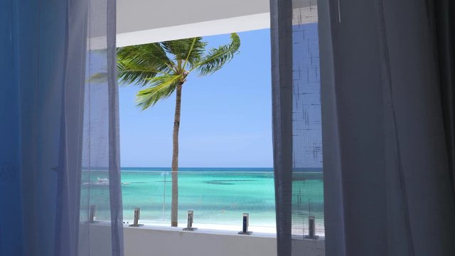 View from balcony resort on caribbean seashore with coconut palm tree and turquoise sea. Travel destinations. Summer vacation