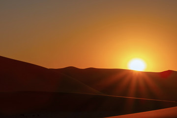 Fototapeta na wymiar Sunset over the sand dunes in the Namib desert.