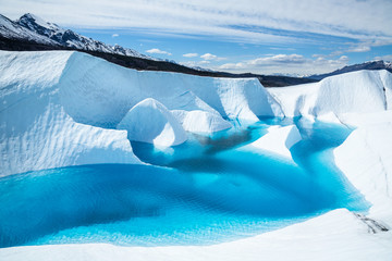 Canyons and fins cut by melting ice on the Matnauska Glacier in Alaska. The canyons have been flooded by high spring melt with water turning a deep blue. - Powered by Adobe