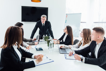 Speaker standing and lecturing on business conference in meeting hall ..