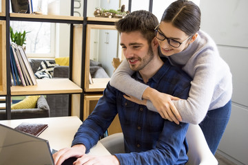 beautiful guy and girl are working on a laptop, students, smiling, hugging