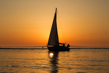 yacht with a sail at sunset in the sea