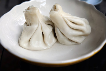Two Georgian khinkali on a plate. Traditional food in Georgia. Delicious Georgian dishes.