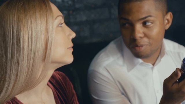 Multicultural happy people meet in cafe and comunicate, african and caucasian people talking at coffee shop, drinking coffee and smoking vape.