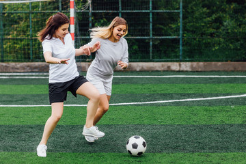Two, young female soccer players , wear at uniform, on the field. Activity and sport concept.