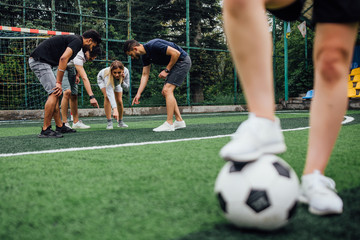 Young soccer player with ball in action outdoors. Team play concept.
