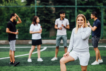 Obraz na płótnie Canvas What about new palyer. Young, blonde woman smiling and happy, football team.