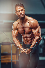 Fototapeta na wymiar Handsome Muscular Men Exercise at the Gym