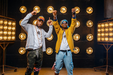 Two black rappers in caps, perfomance on stage