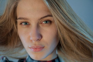 beautiful blonde with blue eyes in plaid dress touches her hair. Young actress shows acting exercises. woman actively expresses her emotions and poses for camera