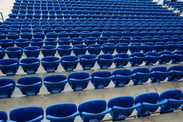 Rows of blue seats in the stand in the sports arena