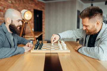 Male chess players begin playing, the first move