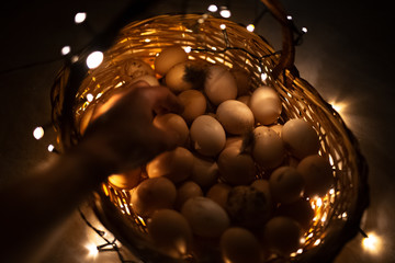 A basket full of chicken eggs surrounded by tiny lights 