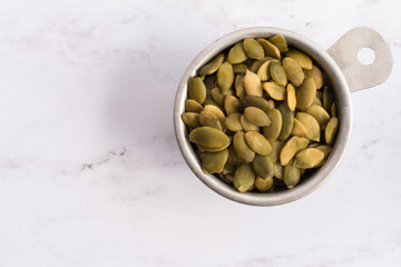 Raw Pumpkin Seeds in a Measuring Bowl