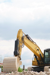 Ein nicht arbeitender Bagger steht auf dem Schutthaufen einer Baustelle. ..