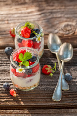 Closeup of oat flakes with berries and yoghurt in jar