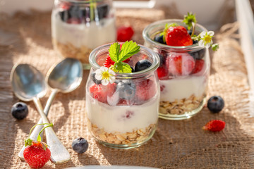 Closeup of oat flakes in jar with yoghurt and berries