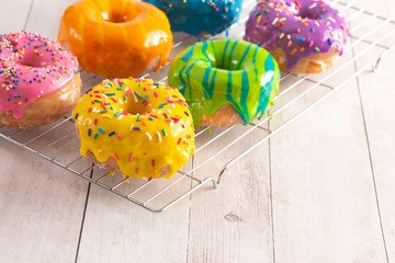 A Batch of Rainbow Donuts on a White Wood Table