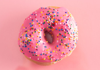 A Pink Sprinkle Donuts on a Pink Background