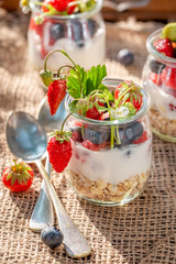 Homemade oat flakes in jar with berries and yoghurt