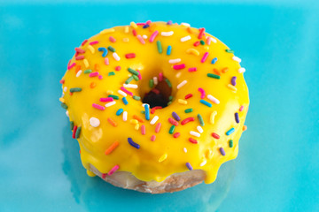 Yellow Sprinkle Donut on a Blue Background