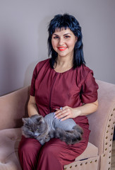 Obraz premium A woman in a medical suit with a cat. Woman doctor with a cat. Gray cat.
