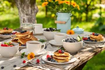 Homemade pancakes served with coffee in summer garden