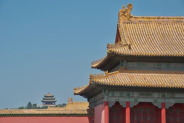 Traditional Chinese building: yellow roof, red columns, ornate painting. Pagoda in distance