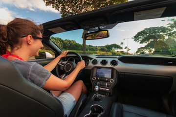 Woman behind the wheel of a convertible car