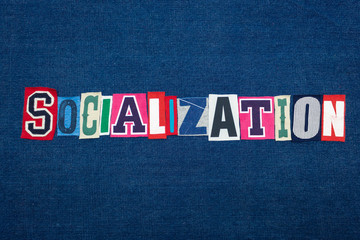 SOCIALIZATION collage of word text, multi colored fabric on blue denim, socially adept and confidence concept, horizontal aspect