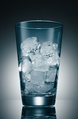Blue glass with ice cubes on the background of a round gradient