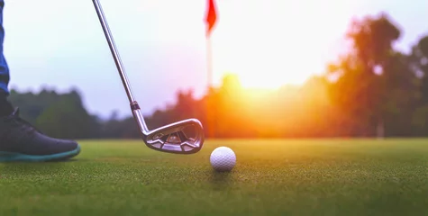 Deurstickers Golf balls and golf club on green grass shiny light sunse © Krailas