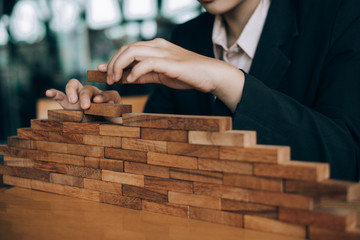 young beautiful businesswoman smiling playing and building wooden at the office, investment concept