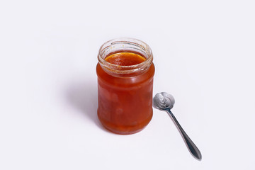Glass jar of jam on a white background
