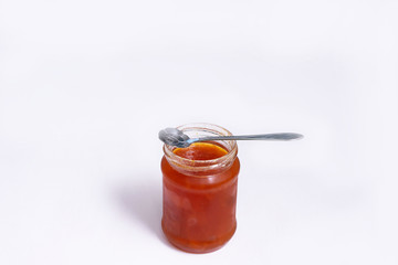 Glass jar of jam on a white background